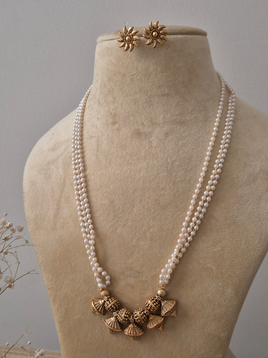 Handcrafted pearl strand necklace with golden jhumka drops and floral stud earrings by Naitri.in