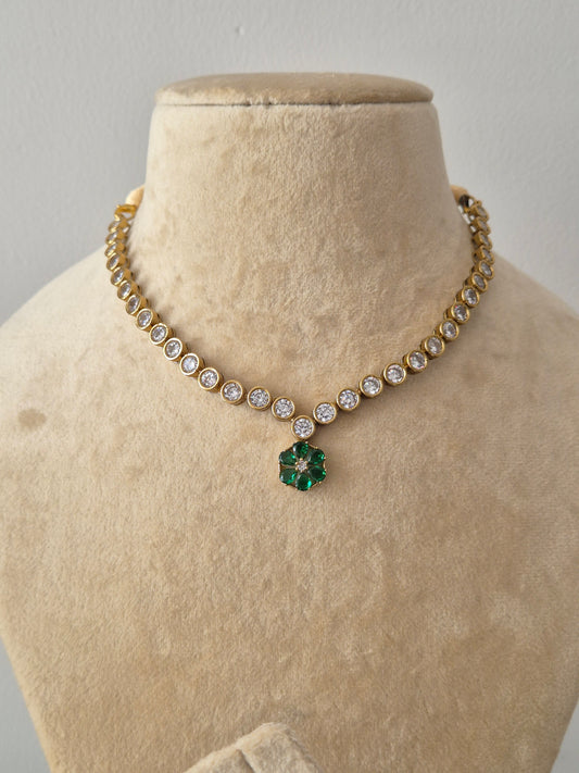 Handcrafted neck piece in brass alloy with a polished golden finish, featuring clear round stones and emerald-green floral accents by naitri.in