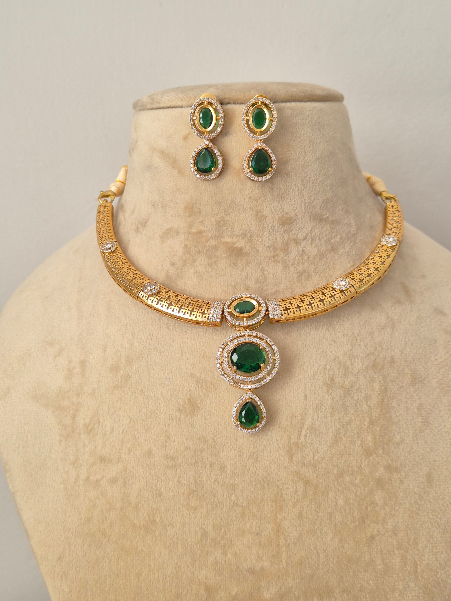 Traditional Indian style golden brass alloy emerald-green choker necklace and earring set from the NAITRI Moumita collection by naitri.in