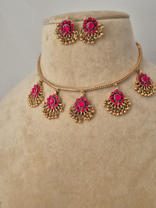 Gold-tone brass alloy necklace featuring five dangling pink stone charms in a fan-shaped design with tiny gold bead drops, paired with matching pink studs by naitri.in