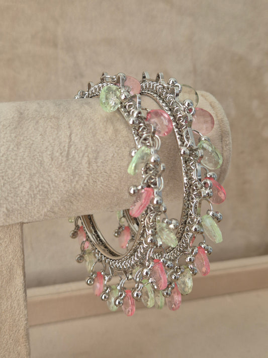 Close-up of Naitri Eartha premium oxidized silver bracelets showcasing traditional Indian tribal craftsmanship with dangling multi-color pastel stone charms