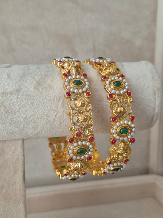 Close-up of Naitri Gaytri premium gold ethnic bangle set with traditional Indian filigree craftsmanship and vibrant gemstone accents. by naitri.in
