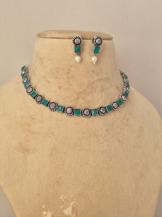 Oxidized silver choker necklace set featuring green stones and dangling mini pearls by Naitri.in