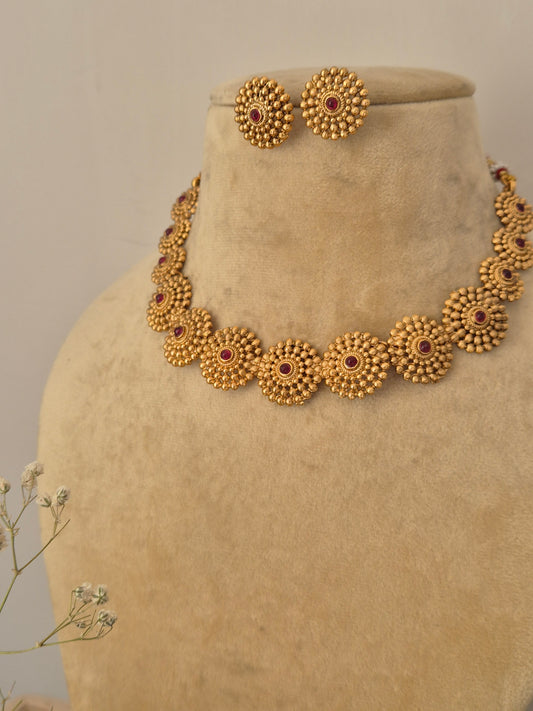 Traditional Indian choker necklace set in polished brass alloy, showcasing intricate textured gold bead detailing and small ruby stone accents from the Naitri collection by naitri.in