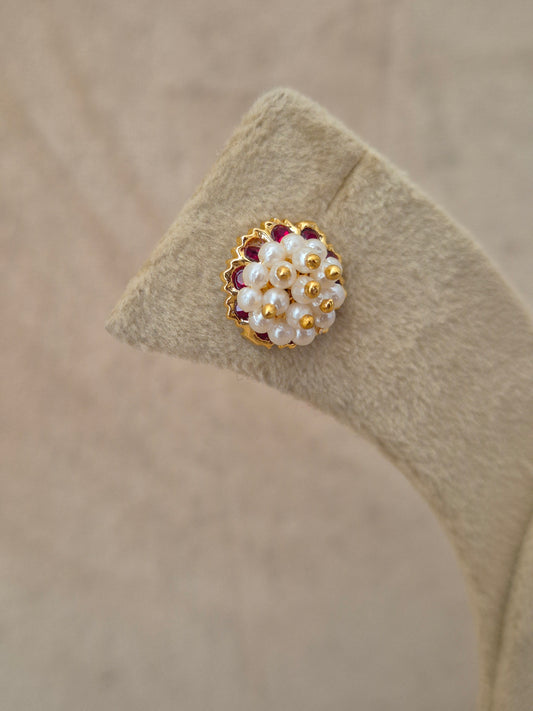 Close-up of Naitri Niyati premium gold ethnic earrings showcasing traditional Indian Jhumka craftsmanship with clustered pearl details and ruby red stone accents by naitri.in