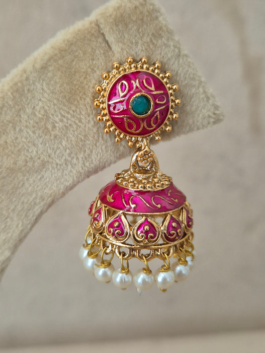 Traditional golden statement earrings with dome-shaped Jhumka drops, decorated with pink ethnic engraving patterns and a bottom layer of clustered tiny white pearls, by naitri.in