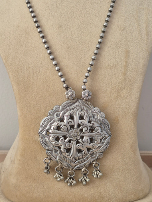 oxidized silver beaded chain necklace with a large, intricately carved geometric pendant featuring dangling bead charms with matching teardrop earrings by naitri.in