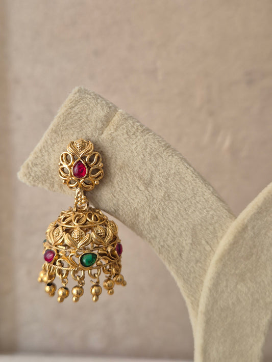 Antique gold-plated Samaya Jhumka earrings featuring ruby-colored stone accents by naitri.in