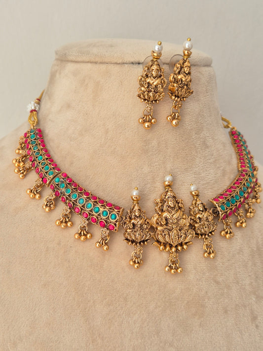 Gold-toned traditional Indian jewelry set featuring a choker necklace and matching earrings, embellished with turquoise and pink stones and small pearl-like accents, by naitri.in