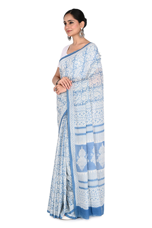 Woman wearing the Zoya hand block printed cotton saree in white and blue with a matching short-sleeved blouse by naitri.in