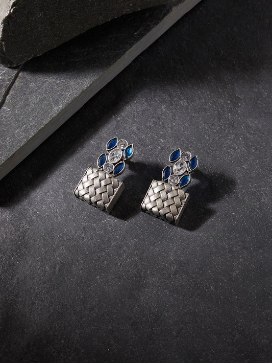 Silver drop earrings in brass and stone, simple background