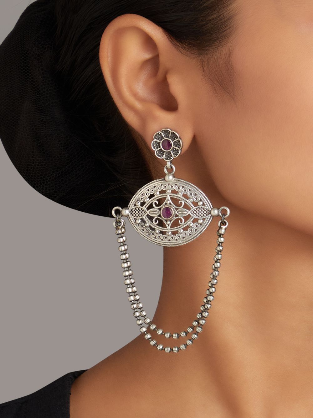 Silver-tone, traditional brass stud earrings shown on dark background