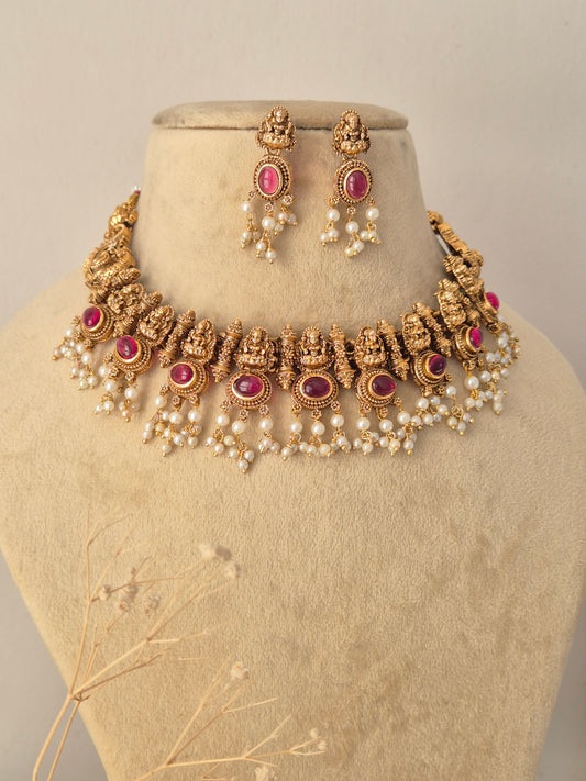 Traditional Indian South Indian Jewelry Set crafted in a rich antique gold finish, showcasing intricate ethnic craftsmanship, vibrant colored gemstones, and layered pearl bead fringe for bridal and festive wear by Naitri.in
