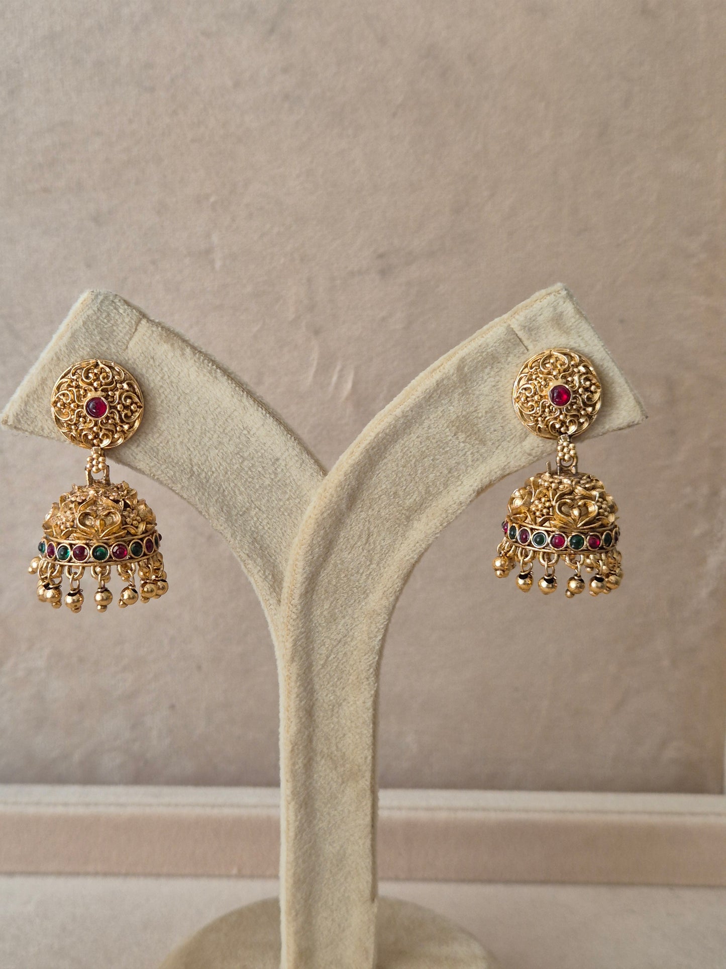 Traditional golden Jhumka earrings with colorful stone accents by naitri.in
