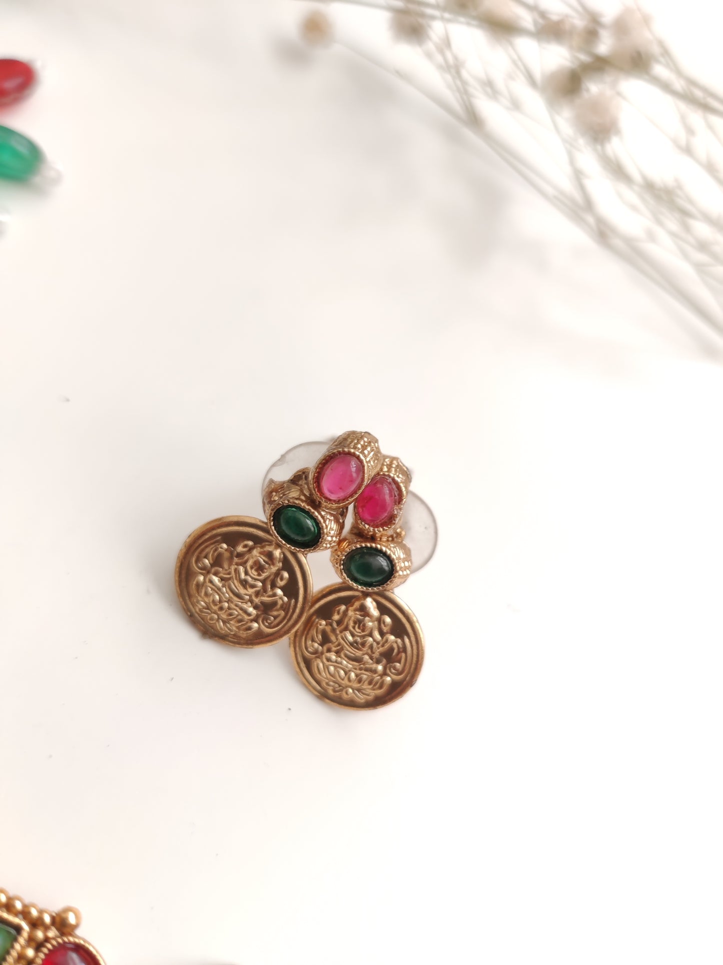 A necklace set with gold- adorned with red gemstones and coin-shaped embellishments by Naitri
