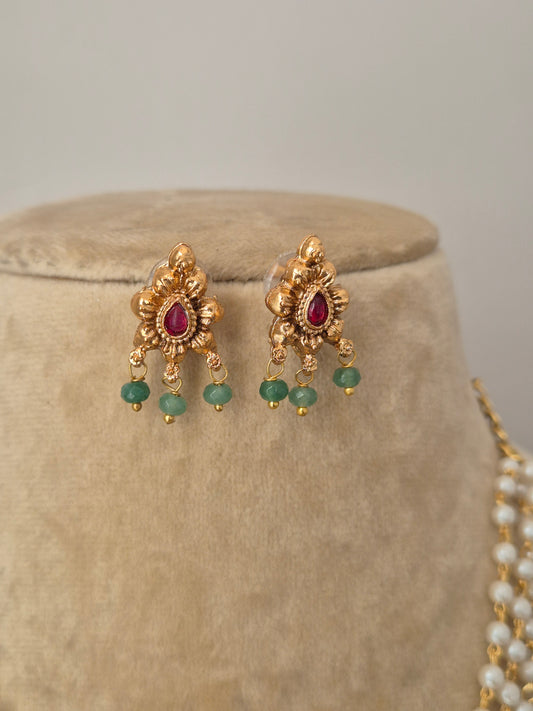 Traditional Indian ethnic necklace set with a white pearl chain, floral gold pendant, and matching stud earrings by naitri.in