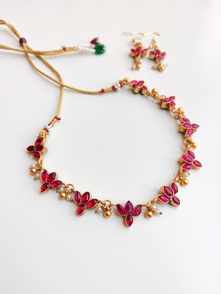 Antique gold-plated Reversible Lotus Temple Jewellery Necklace Set with red and green stones.