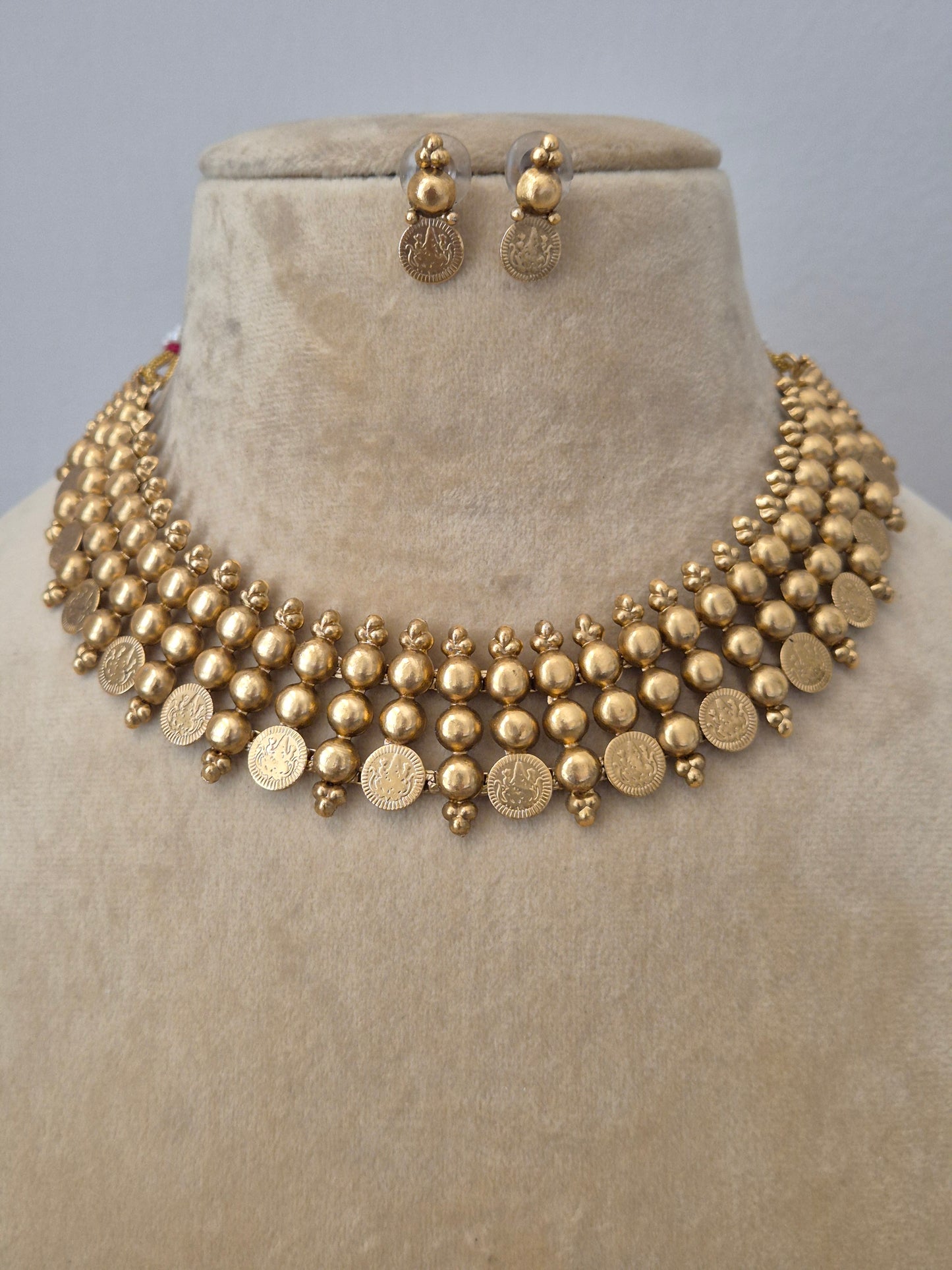 The Sapna Necklace Set by Naitri, a brass alloy matte gold choker with coin details and matching earrings by naitri.in