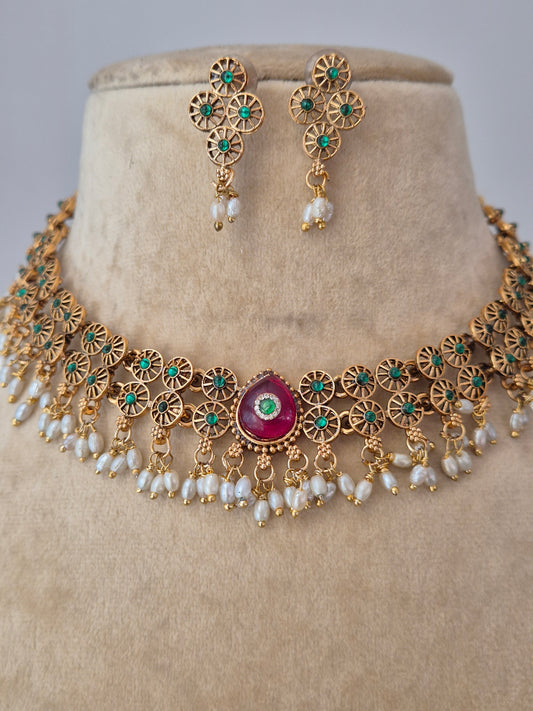 Artisanal gold-finish necklace set with geometric gold spacers and red stone accents, part of the Naitri Golden Jewellery collection with a modern Indian aesthetic by naitri.in