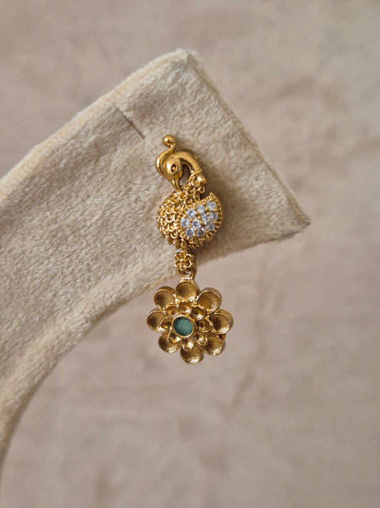 Handcrafted gold earrings with peacock and floral designs, accented by green and white stones in a polished brass finish by naitri.in