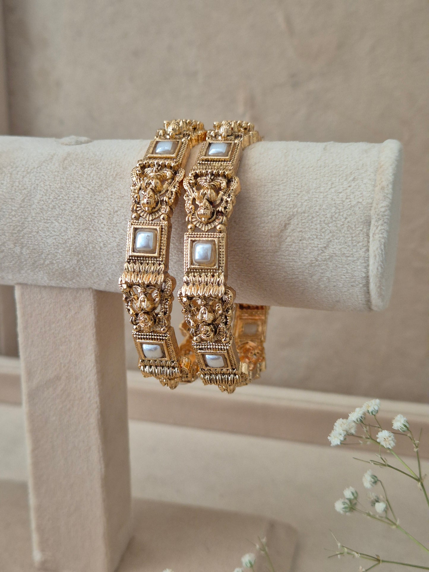 Pair of Naitri's Visha gold bangles showcasing detailed ethnic craftsmanship, embedded with elegant square pearl accents, by naitri.in