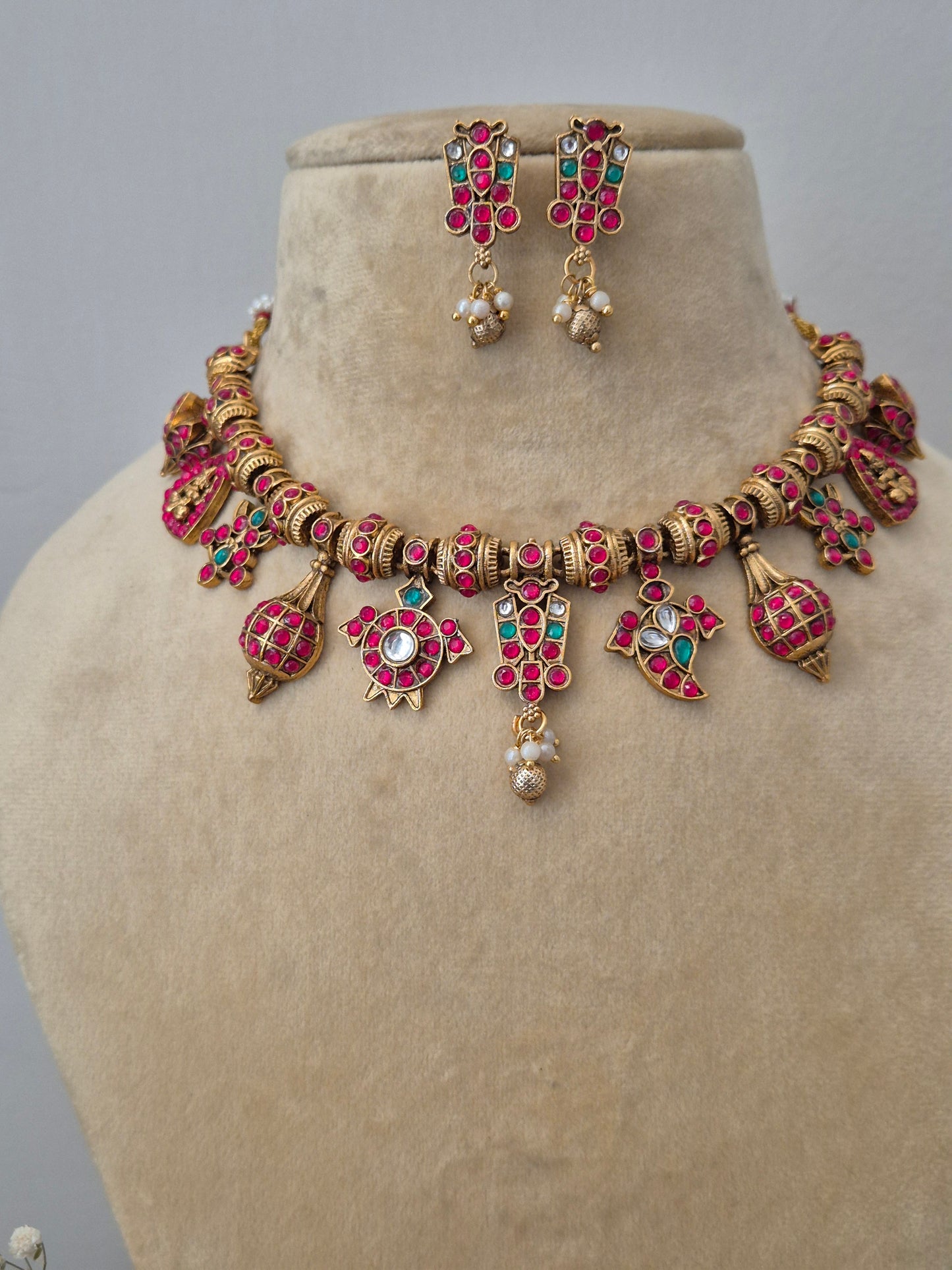 Closeup of the Vritika gold-plated strand necklace and matching small drop earrings by naitri.in