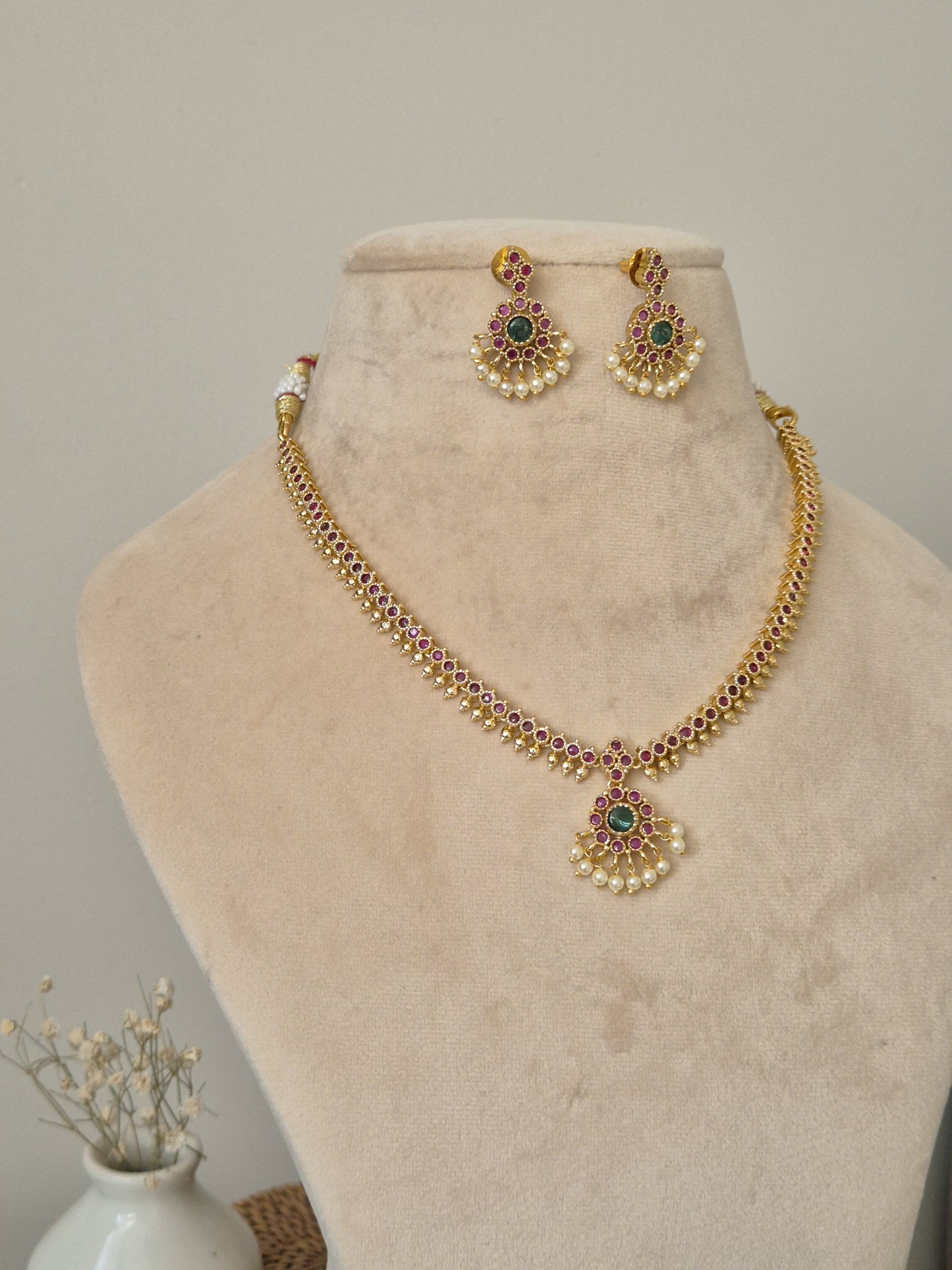 Sophisticated metal alloy necklace set photographed on a plain background to show classic design