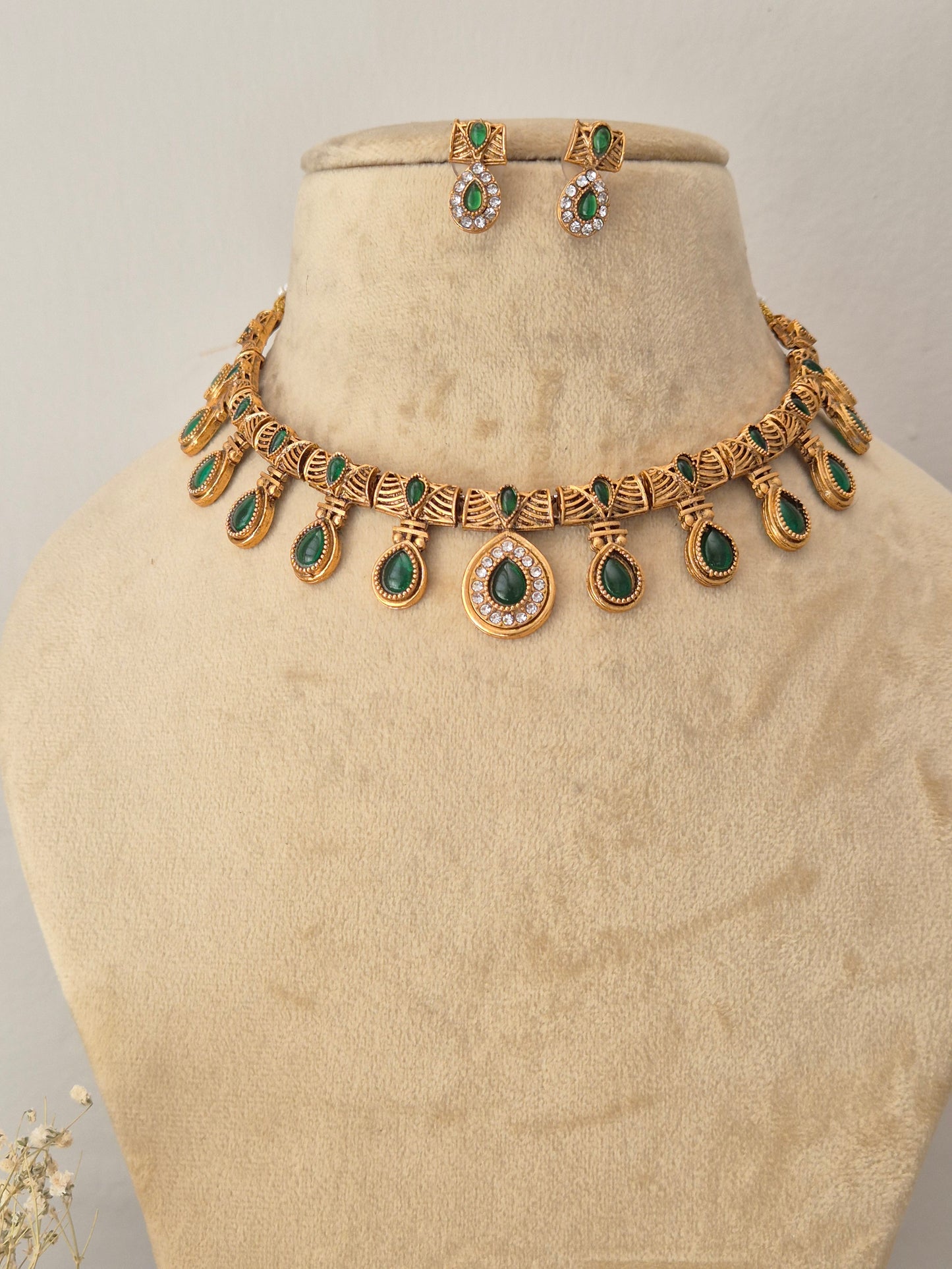 Necklace Set by Naitri featuring an ethnic gold-plated choker and matching traditional drop earrings with green teardrop stones for festive wear by naitri.in