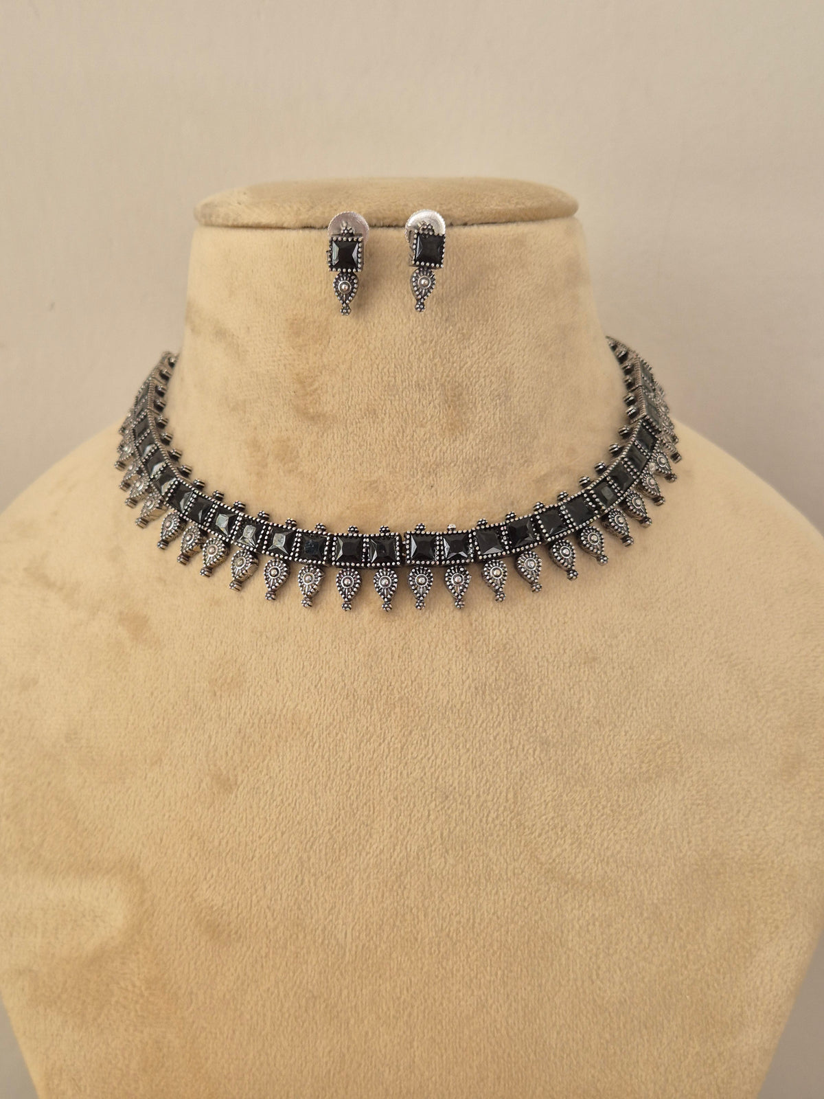 Oxidized silver brass alloy choker necklace set featuring classic Indian motifs and pearl accents by Naitri.in