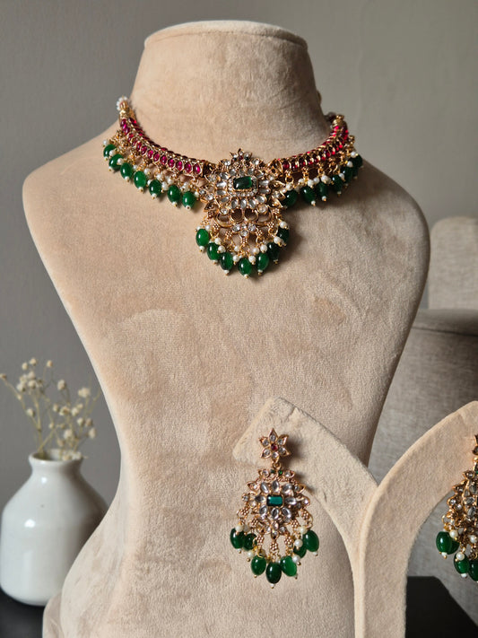 Premium temple necklace set with rich gold, green, and red details photographed on neutral background