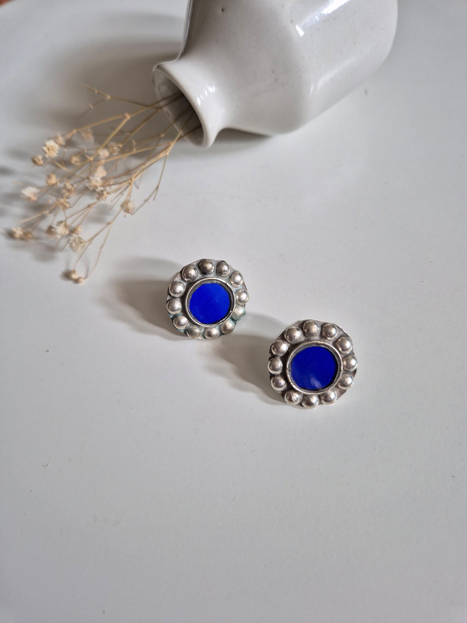 Blue and silver stud earrings, artistic close-up