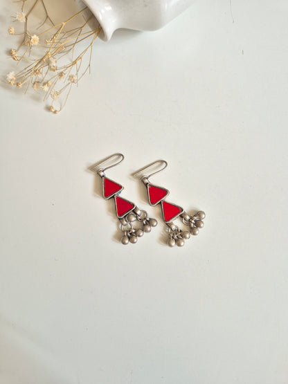 Red glass dangle earrings with silver accents, simple display