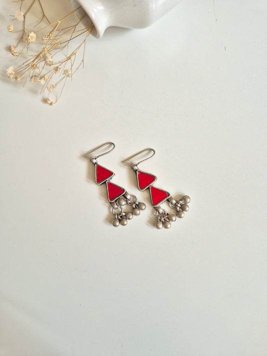 Red glass dangle earrings with silver accents, simple display