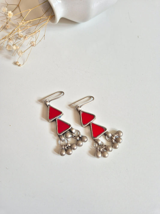 Red glass dangle earrings with silver accents, simple display