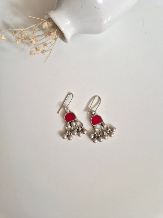 Red and pink glass dangle earrings arranged for color visibility
