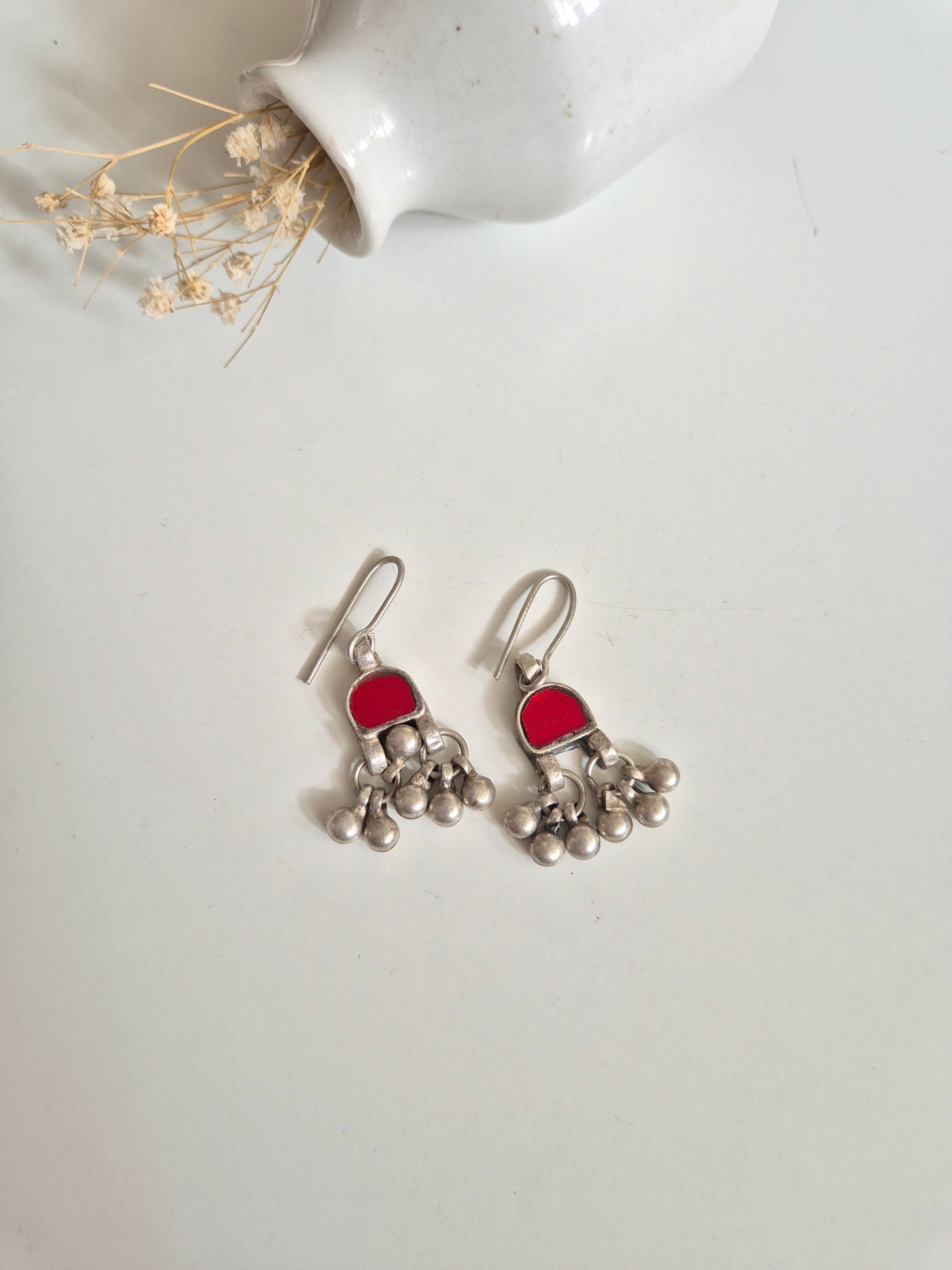 Red and pink glass dangle earrings arranged for color visibility