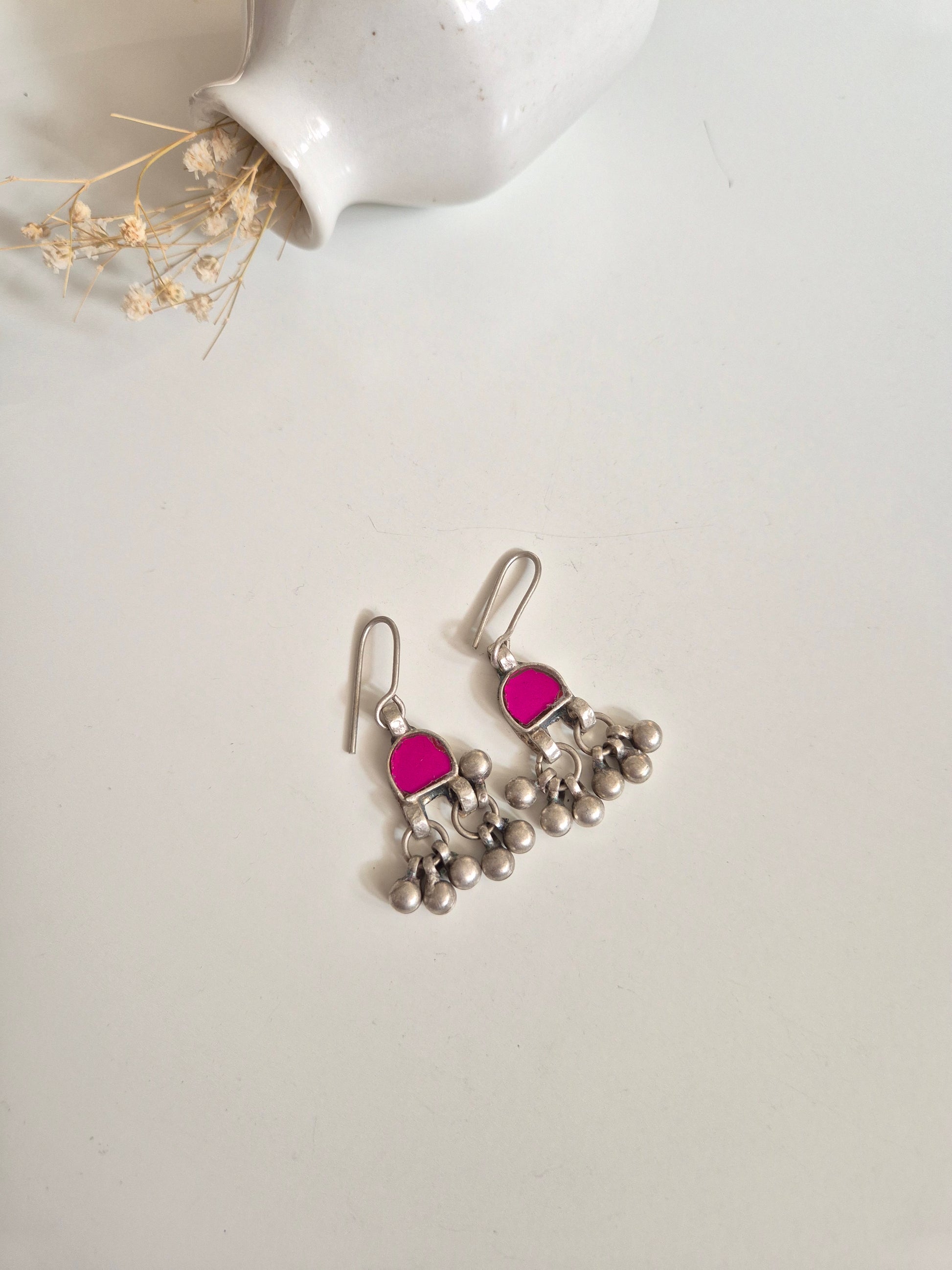 Red and pink glass dangle earrings arranged for color visibility
