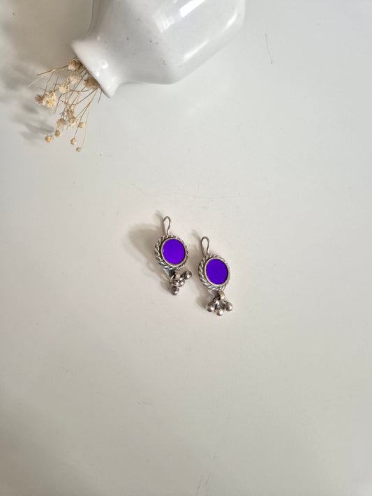 Deep-tone metal and glass earrings, close-up on unique shape