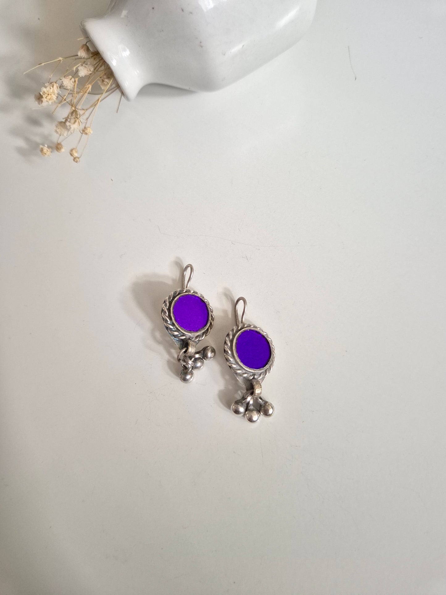 Deep-tone metal and glass earrings, close-up on unique shape