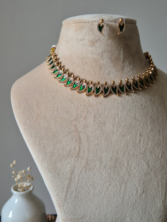 Handcrafted golden necklace set with green stones on neutral background, classic style