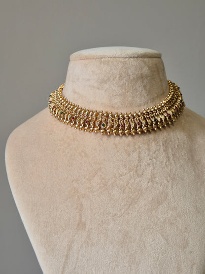 Gold necklace set with red stones, Lipsa by Naitri, classic design shown flat.