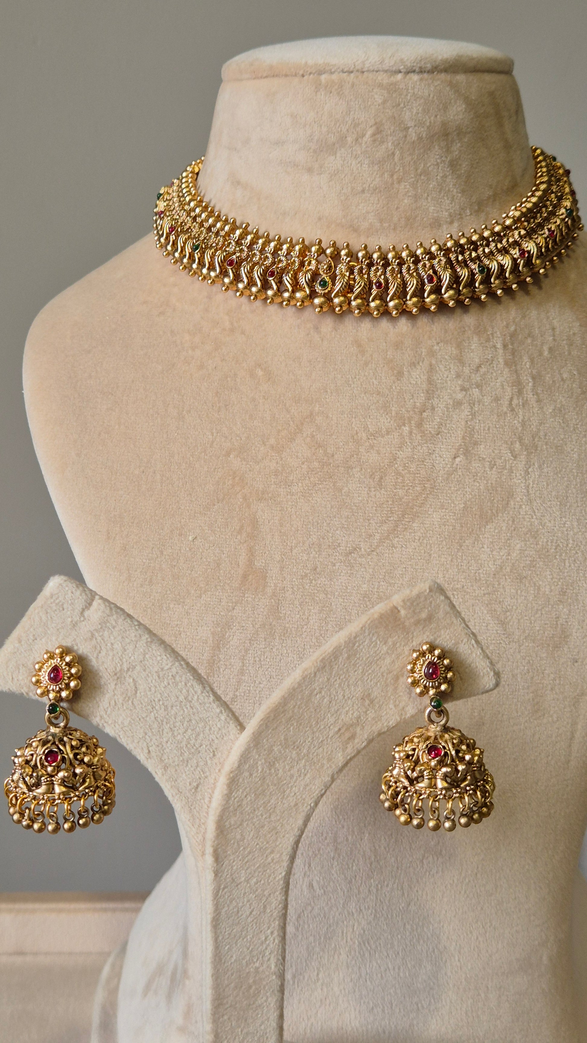 Gold necklace set with red stones, Lipsa by Naitri, classic design shown flat.