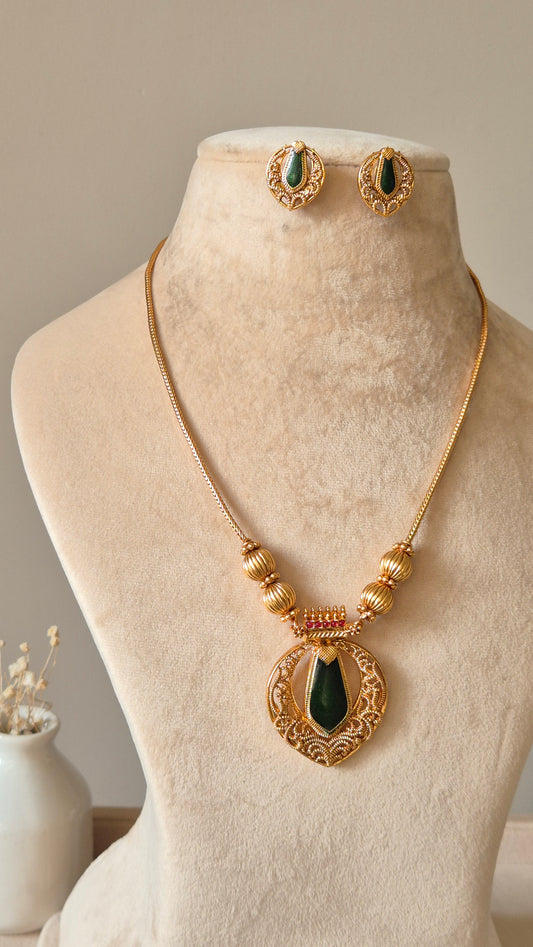 Red and gold necklace set, Angika by Naitri, displayed with matching earrings.