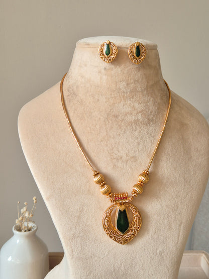 Red and gold necklace set, Angika by Naitri, displayed with matching earrings.