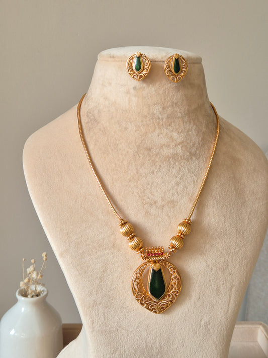 Red and gold necklace set, Angika by Naitri, displayed with matching earrings.
