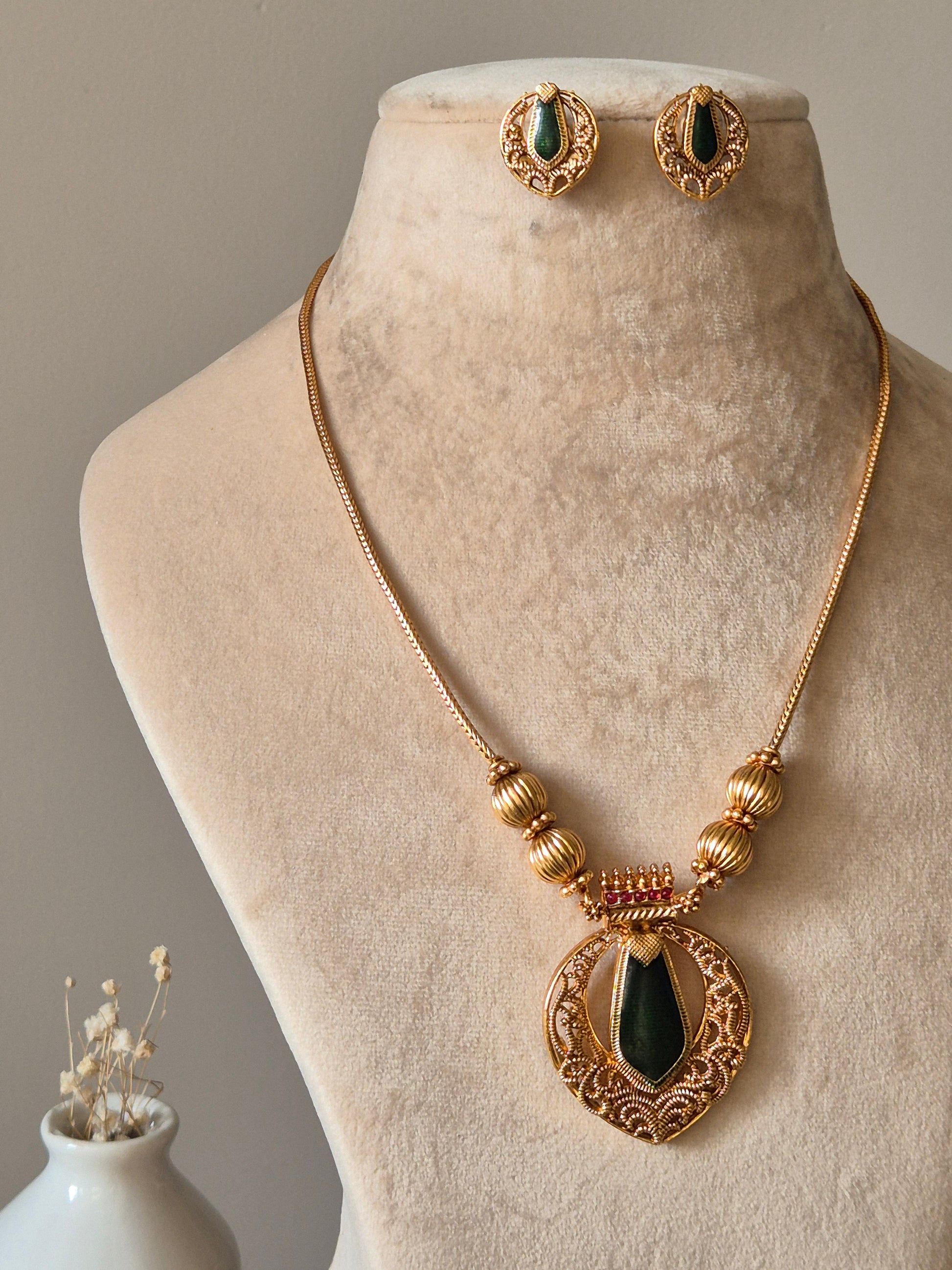 Red and gold necklace set, Angika by Naitri, displayed with matching earrings.