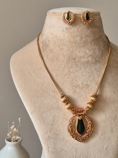 Red and gold necklace set, Angika by Naitri, displayed with matching earrings.