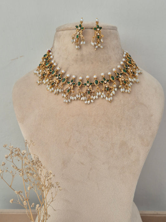 Ladli gold-toned choker necklace set with green stone floral motifs, pearl drops, and matching earrings