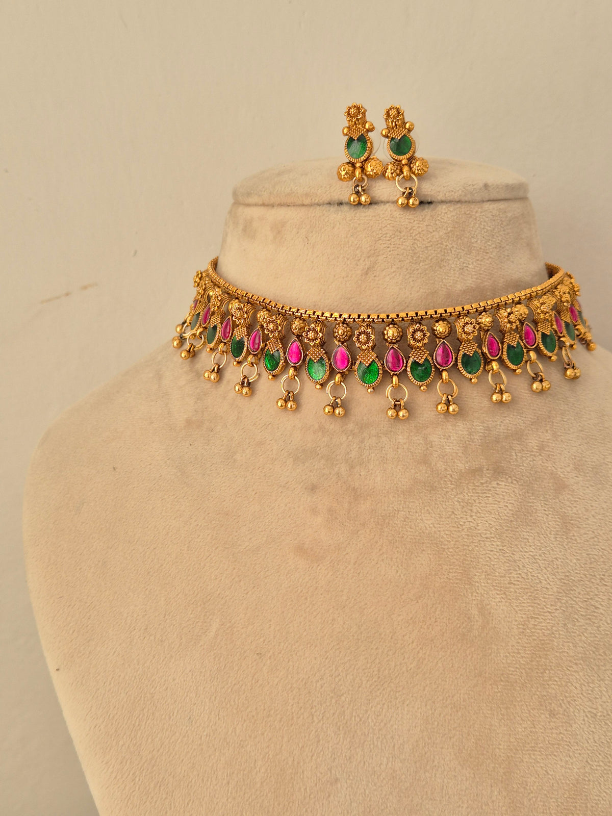 Gold-toned ethnic necklace and matching earrings with green and pink stone embellishments