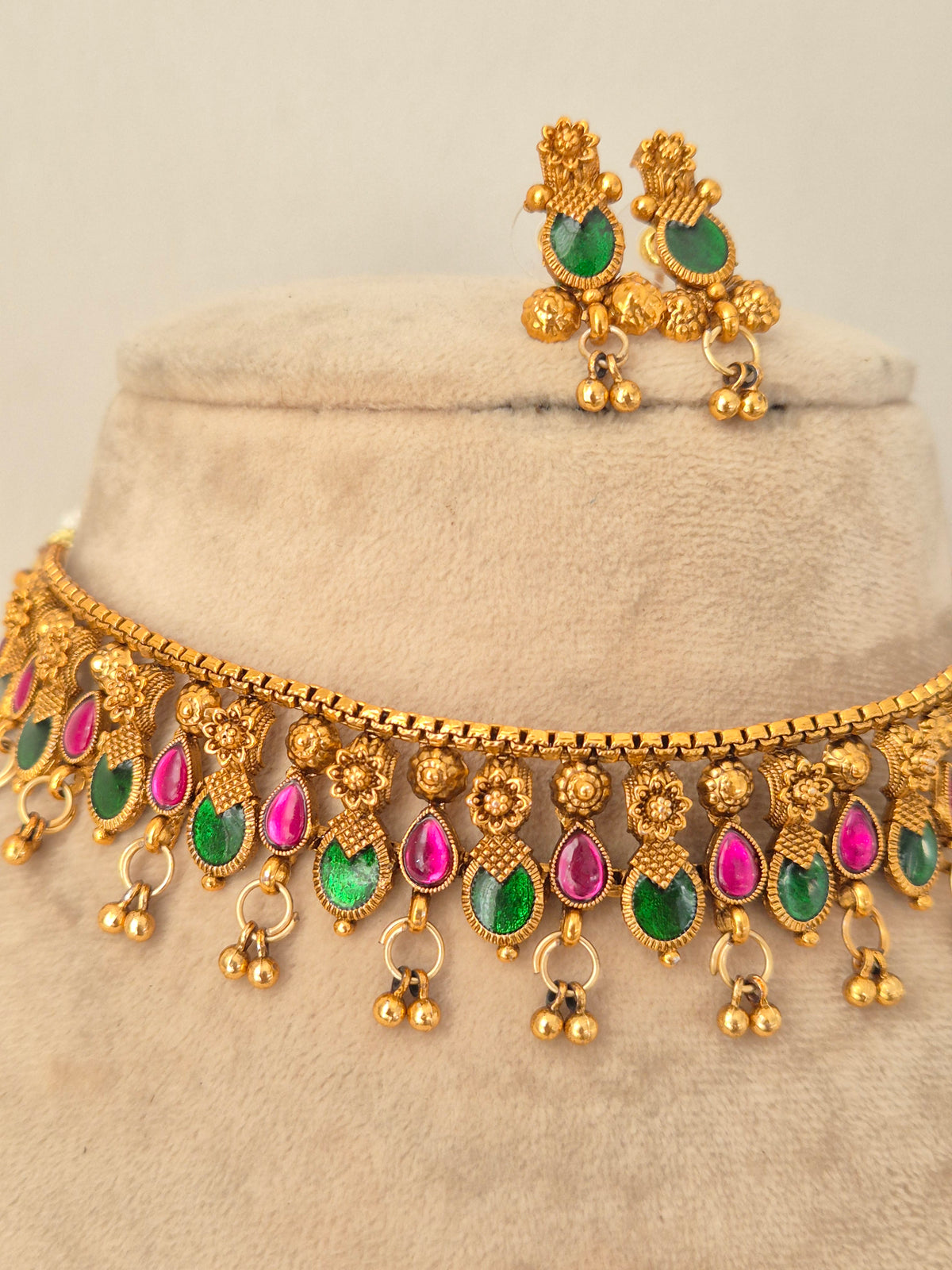 Naitri Wilina Necklace Set featuring traditional gold-finish craftsmanship with pink and green stone accents